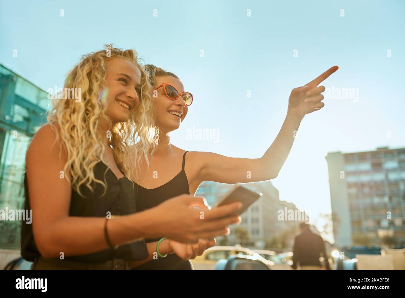 That way. two attractive young women exploring the city sights with the help of a cellphone. Stock Photo
