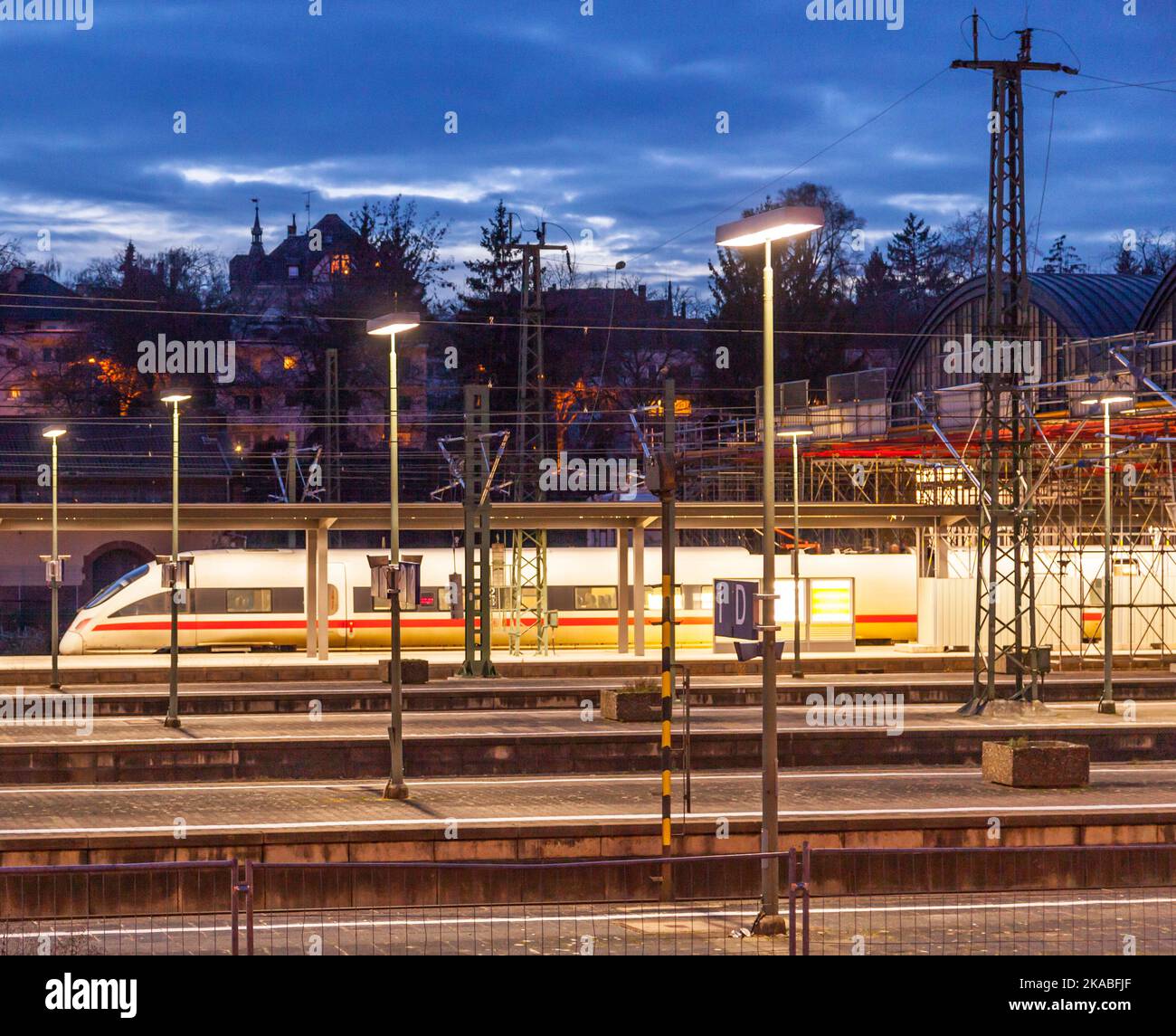 evening train traffic with rails and illuminated platform in the dark ...