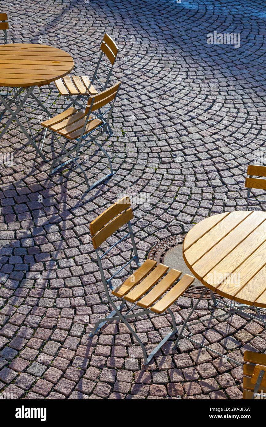 Outdoor German cafe seating with round tables and wooden chairs Stock