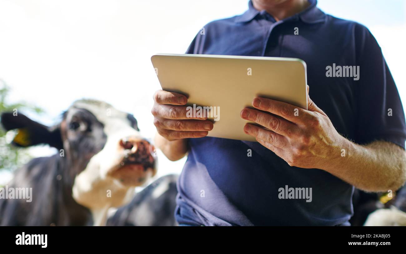 The modern farmers assistant. a farmer using a digital tablet on his