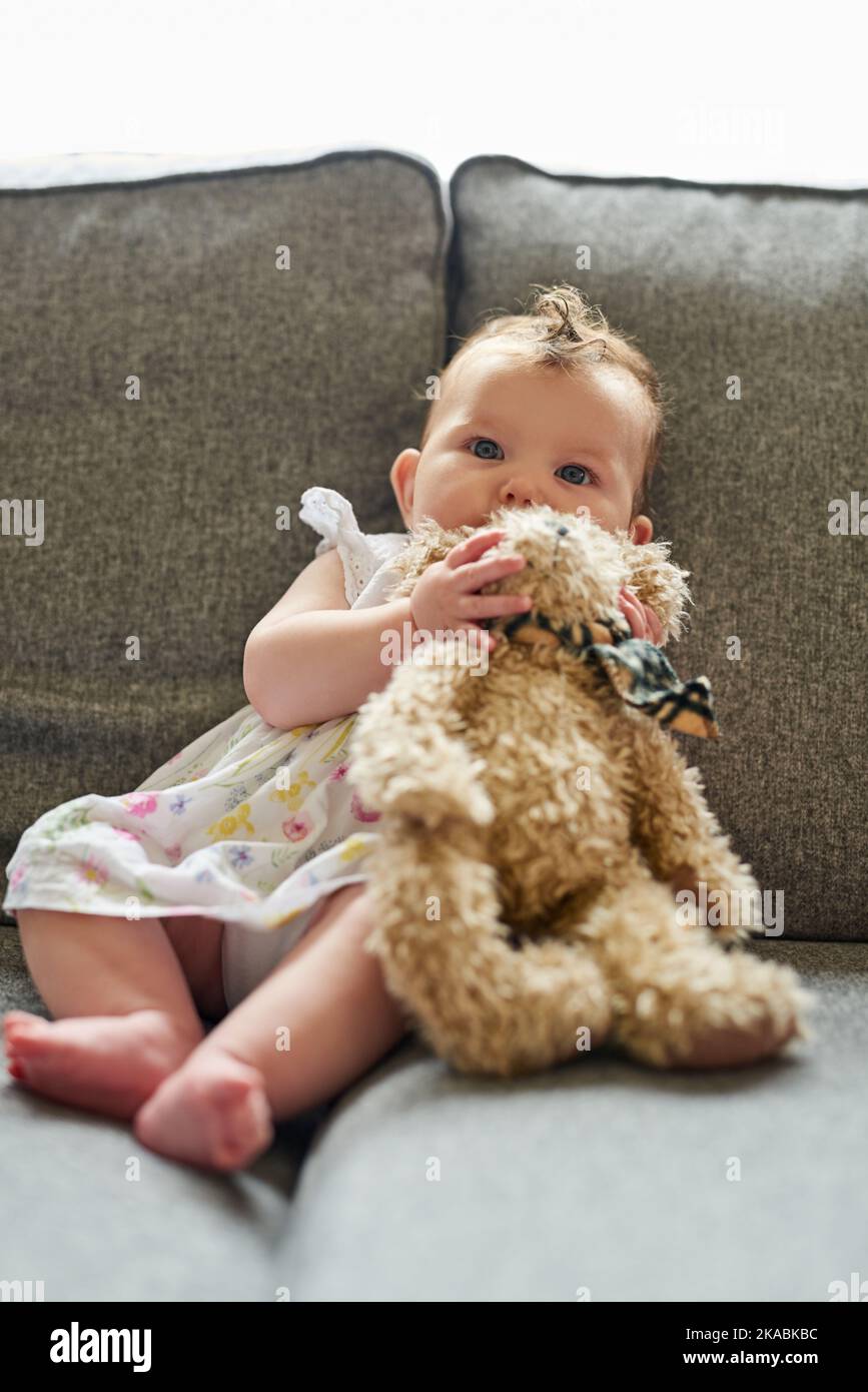 Its her favourite teddy. Portrait of an adorable baby girl playing with a teddybear at home. Stock Photo