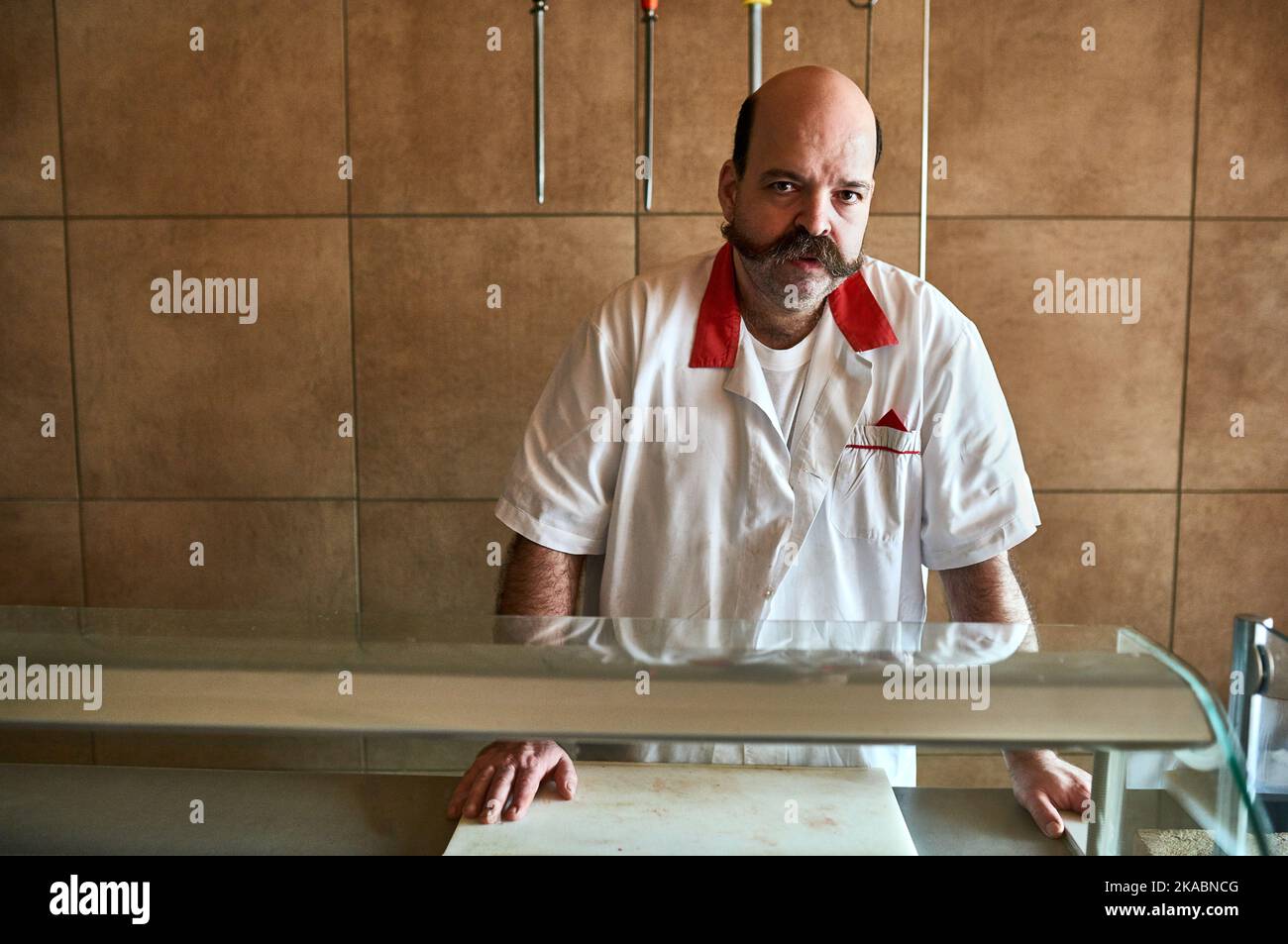 He knows the in and outs of the butchery business. a butcher at his store. Stock Photo