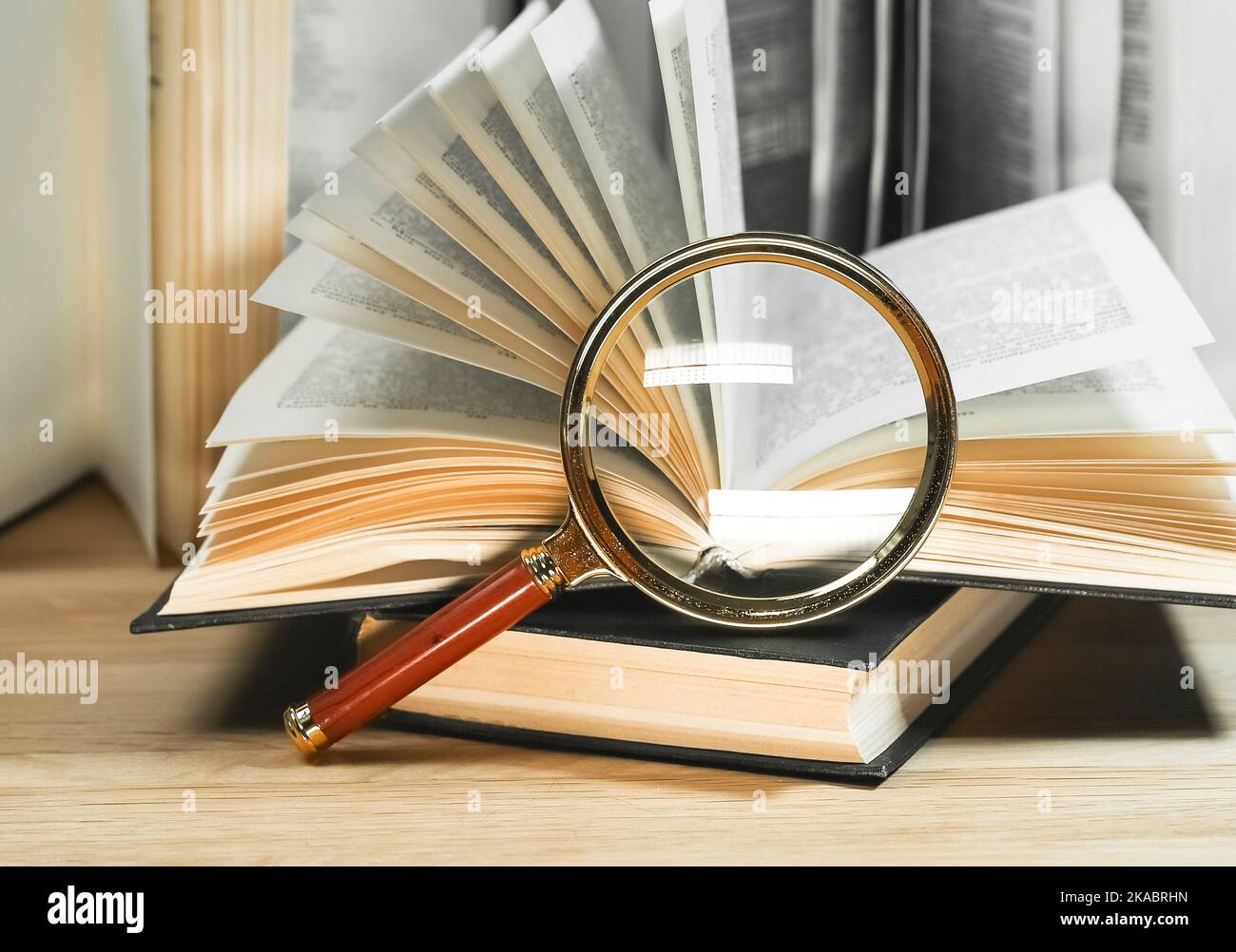 Magnifiers and books with turning pages on wood table. Reading and