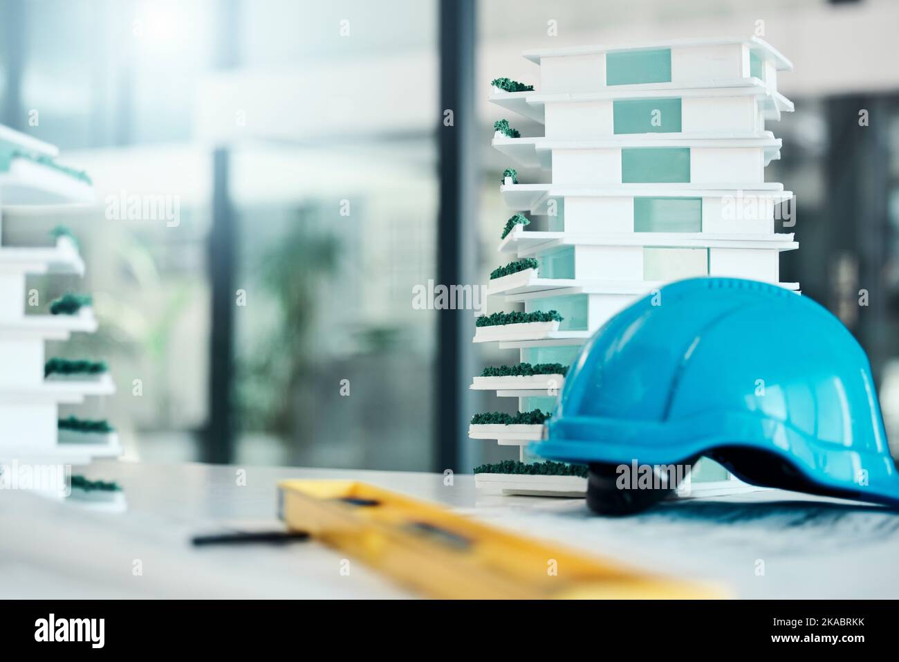 Building model on table, construction design industry and safety helmet