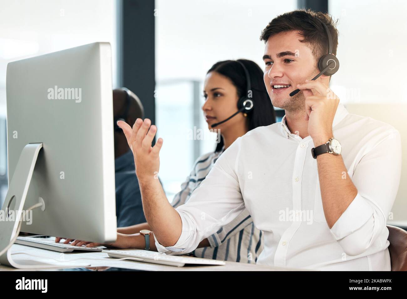 Computer customer support and crm man employee on an office phone consultation. Speaking internet and web call center employee consultant with headset Stock Photo