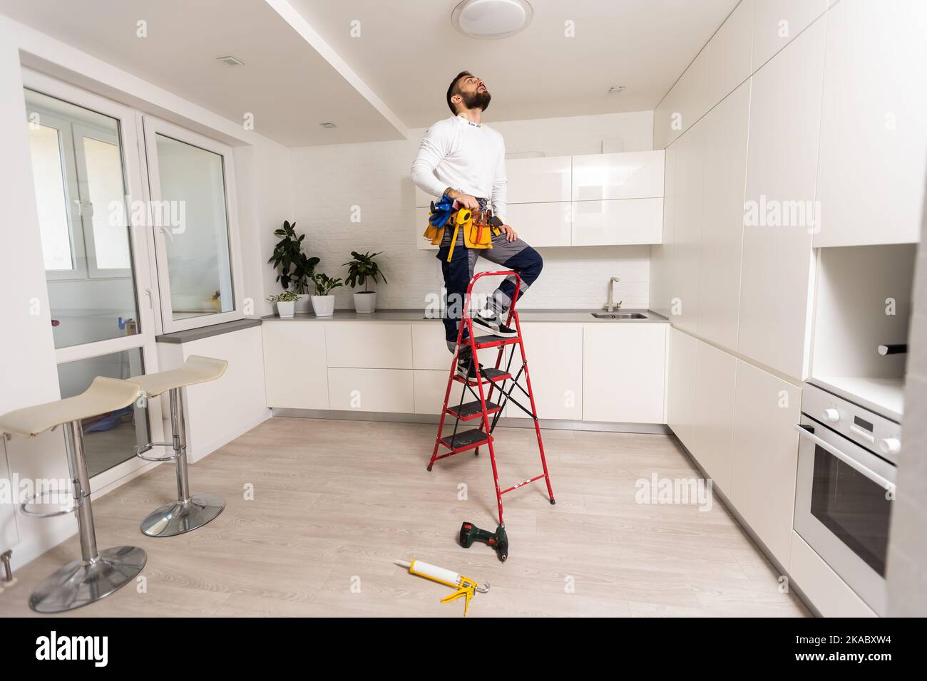electrician installing led light bulbs in ceiling lamp Stock Photo