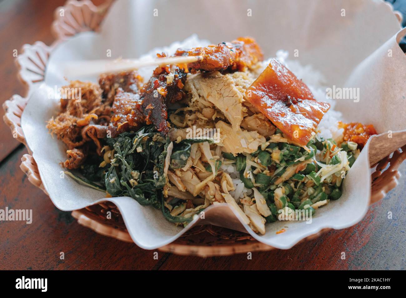 A plate of Balinese typical food called nasi babi guling or pork roll with rice in English, specialty consisting of pork meat, pork belly, pork skin, Stock Photo