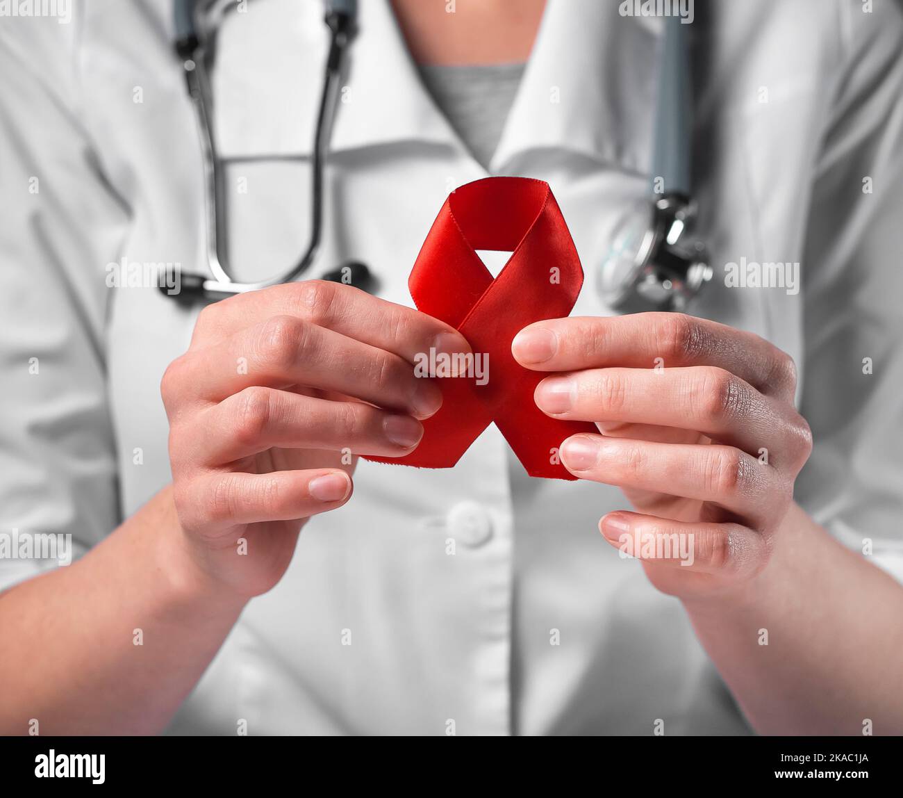 Red ribbon bow in doctor hands. HIV and AIDS concept Stock Photo - Alamy