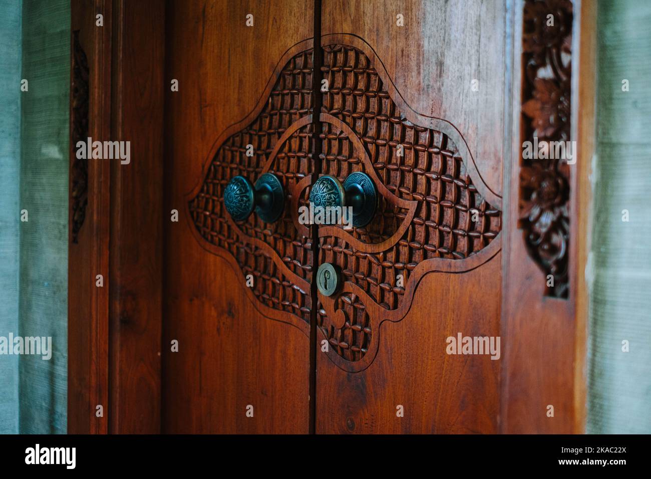 Door which made from Teak Wood carved with artistic cloud shaped in a resort in Ubud, Bali Stock Photo