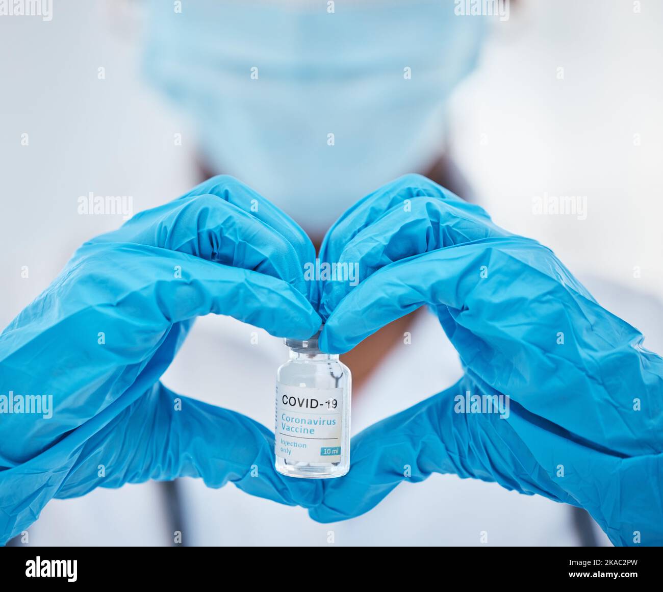 Doctor hands, heart sign and covid vaccine for health, wellness and safety from virus, flu and disease. Medical expert with love icon, emoji and Stock Photo