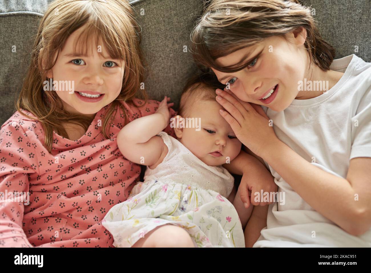 I love my siblings. siblings sitting on a couch together indoors. Stock Photo