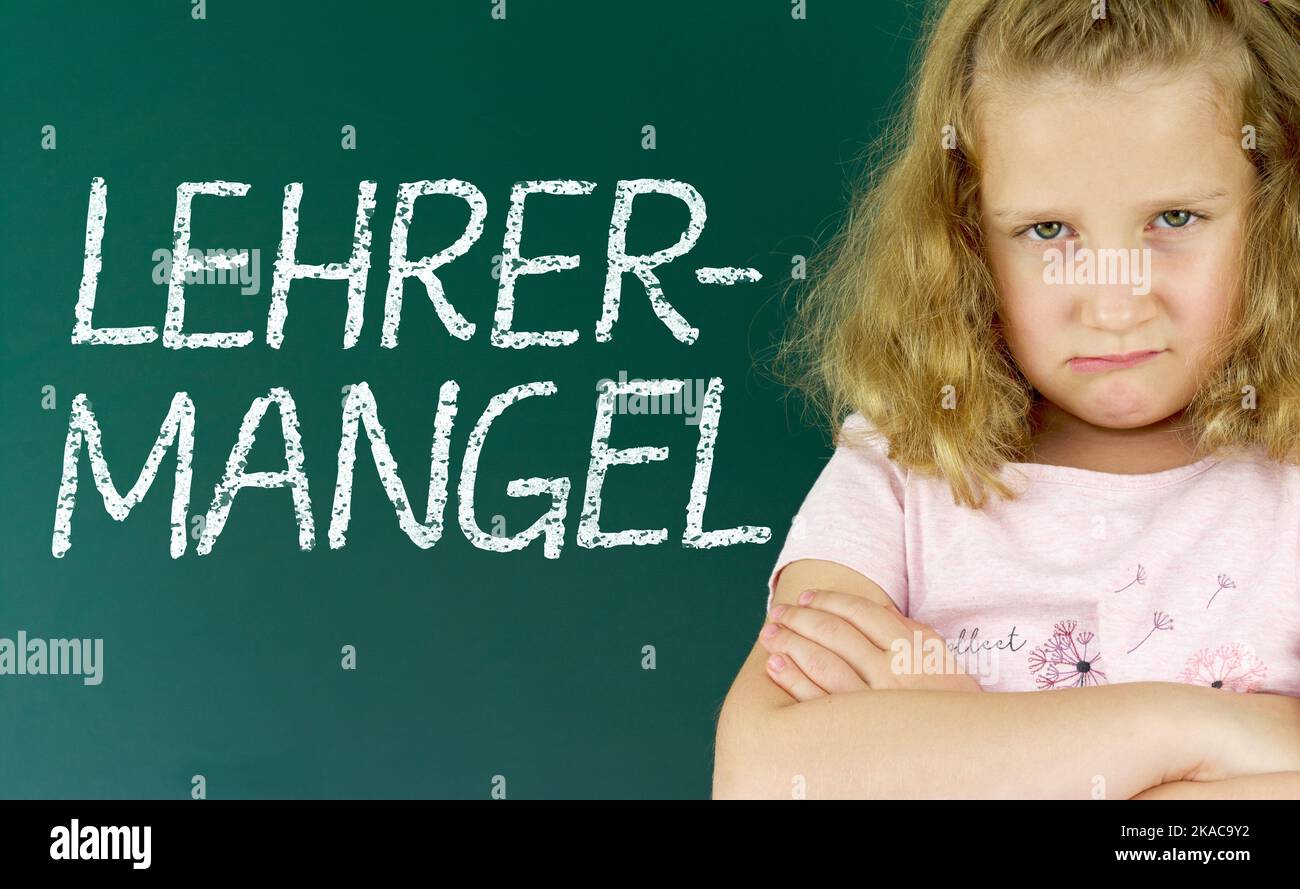 Pupil in front of a blackboard with the German word: Lehrermangel (teacher shortage) Stock Photo