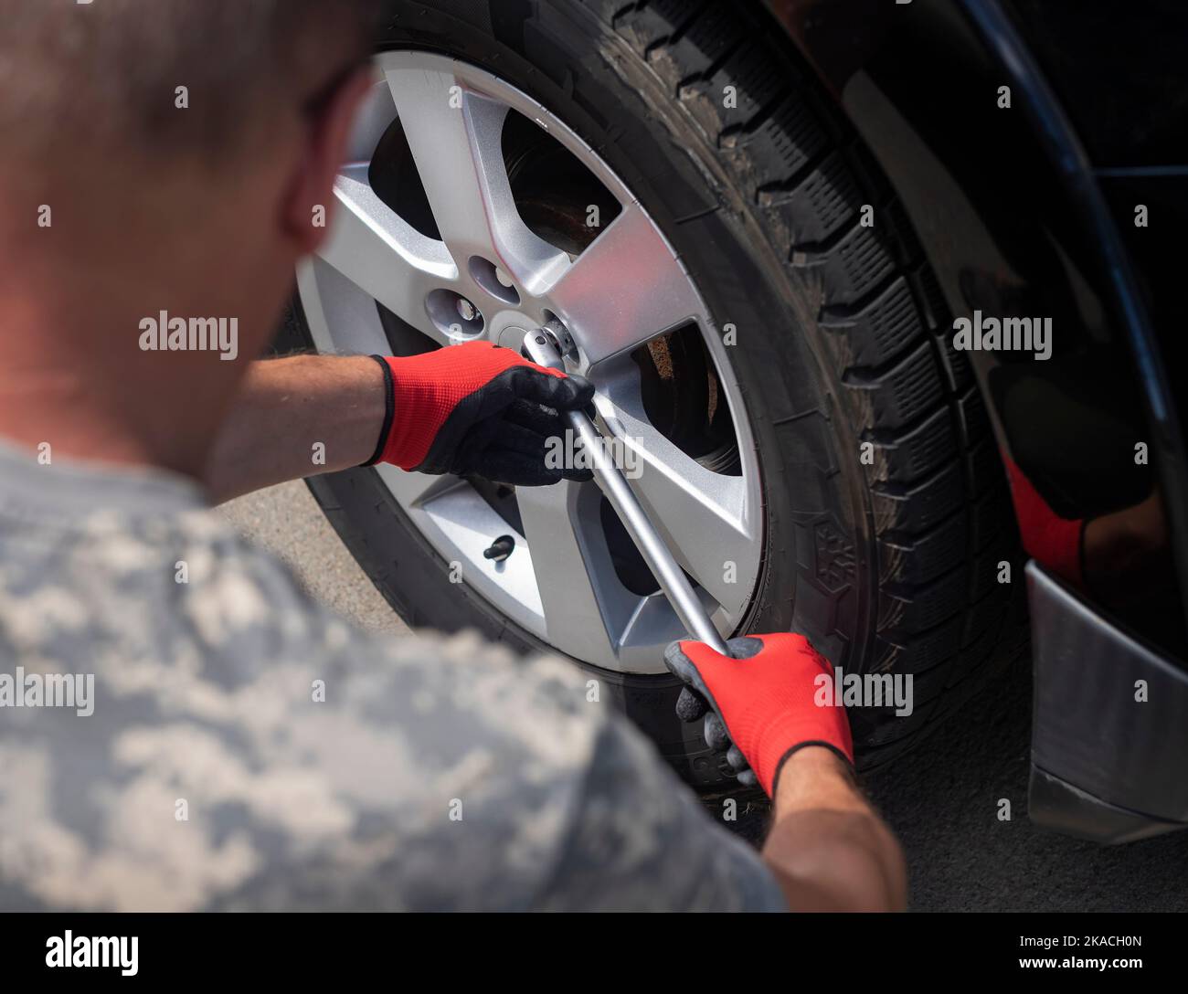 Fixing and checking wheel tire of car with manual tool, closeup Stock
