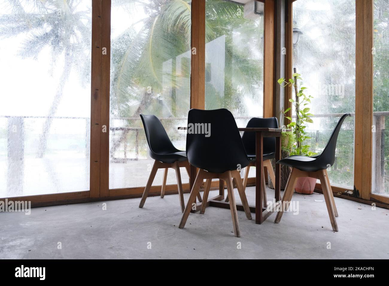 The table and chair set in an empty space with outdoor raining scene at ...