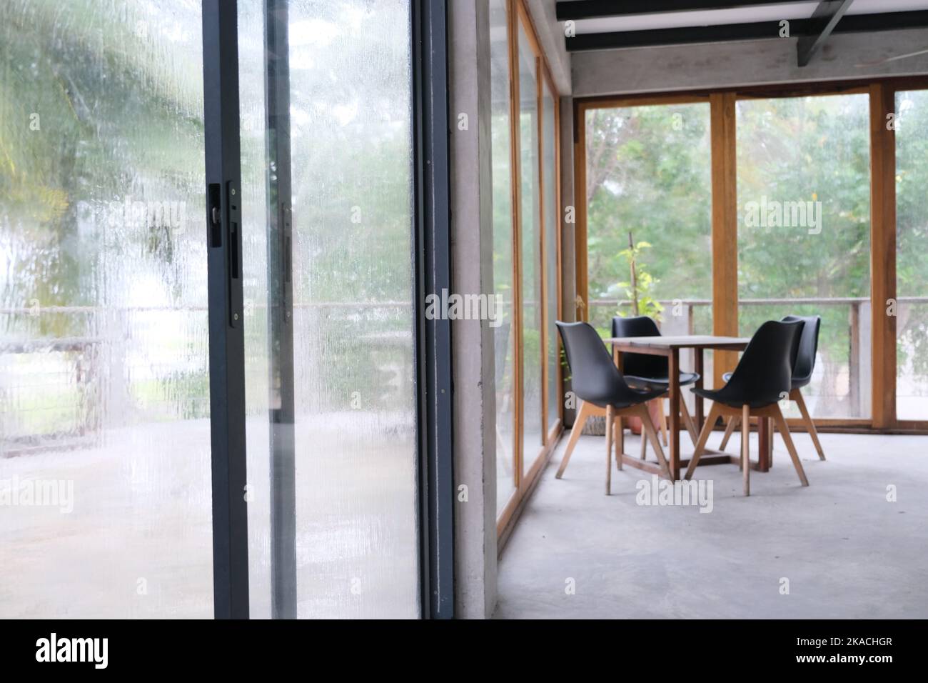 The table and chair set in an empty space with outdoor raining scene at ...
