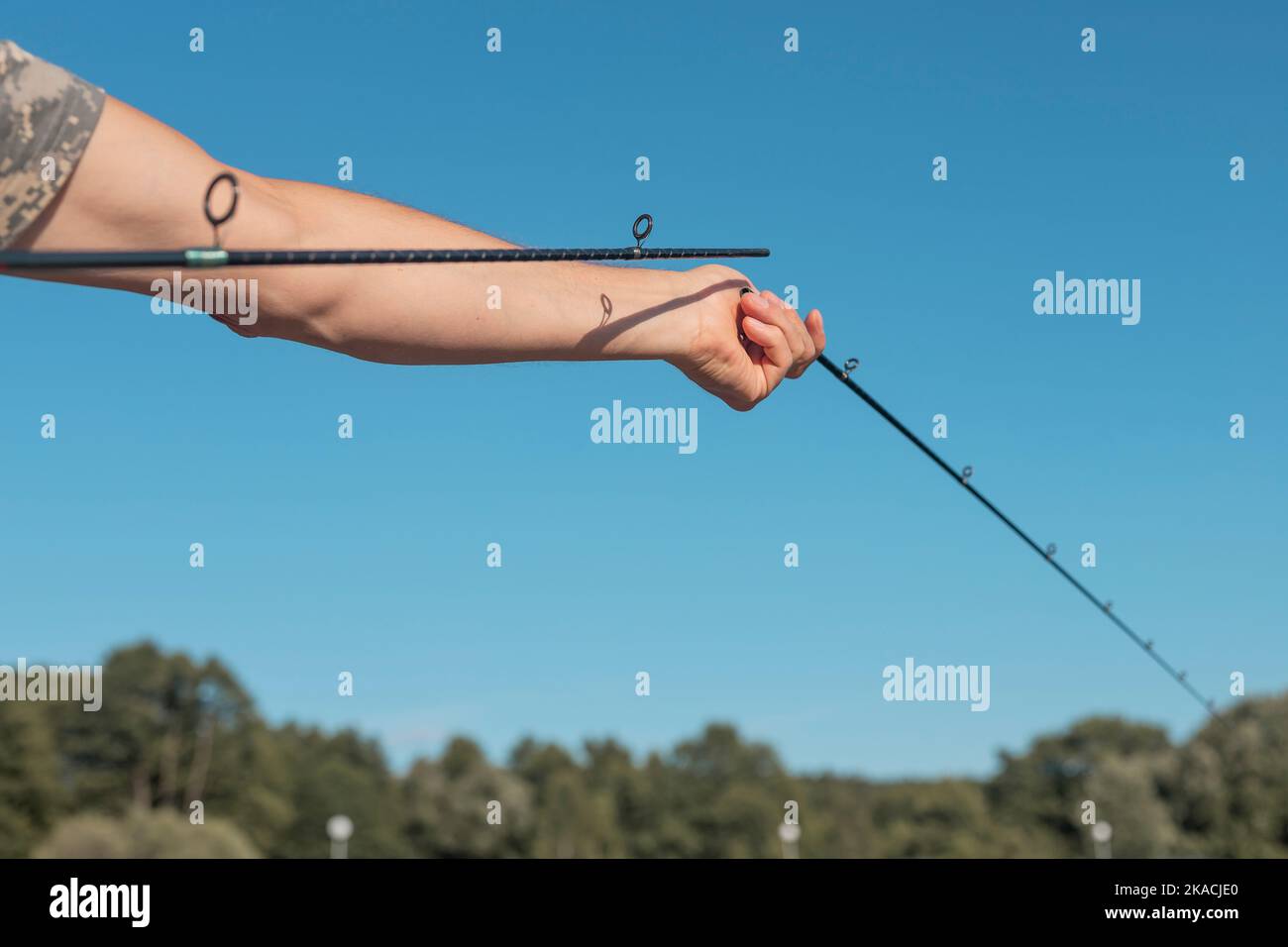 Male hands holding broken fishing rod and assembling it over blue clear sky  in summer Stock Photo - Alamy