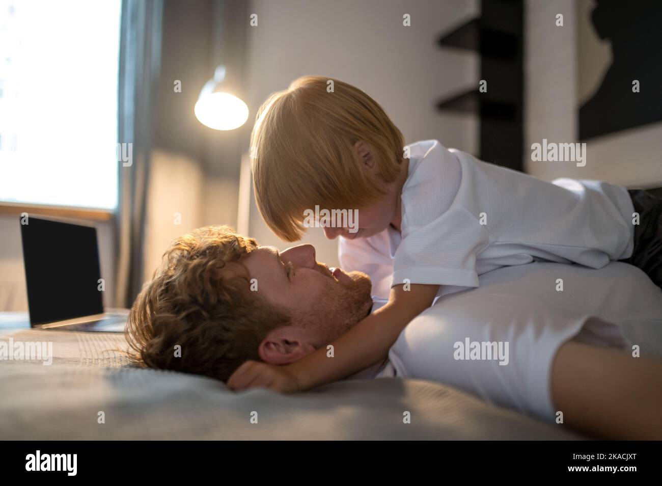 Ginger young man playing with his cute little son Stock Photo