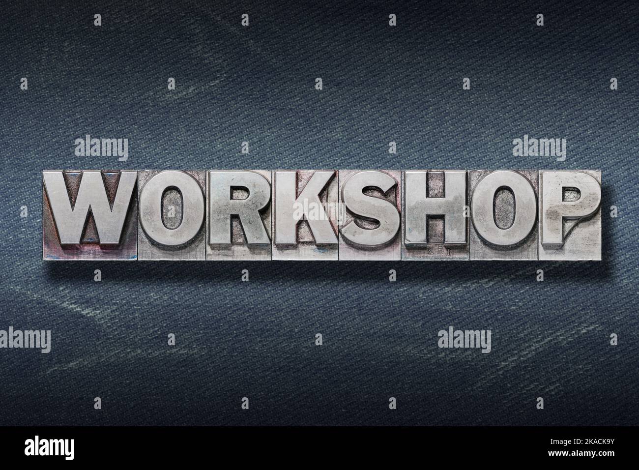 workshop word made from metallic letterpress on dark jeans background Stock Photo