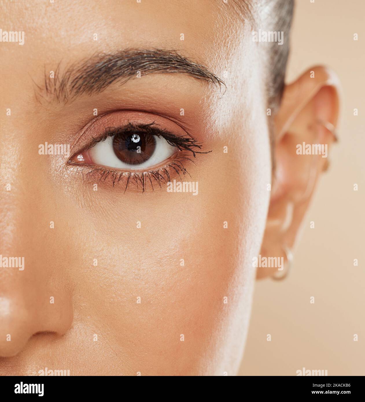 Eye, vision and beauty with a model woman closeup in studio on a beige background for eyecare or skincare. Zoom, cosmetics and wellness with a female Stock Photo