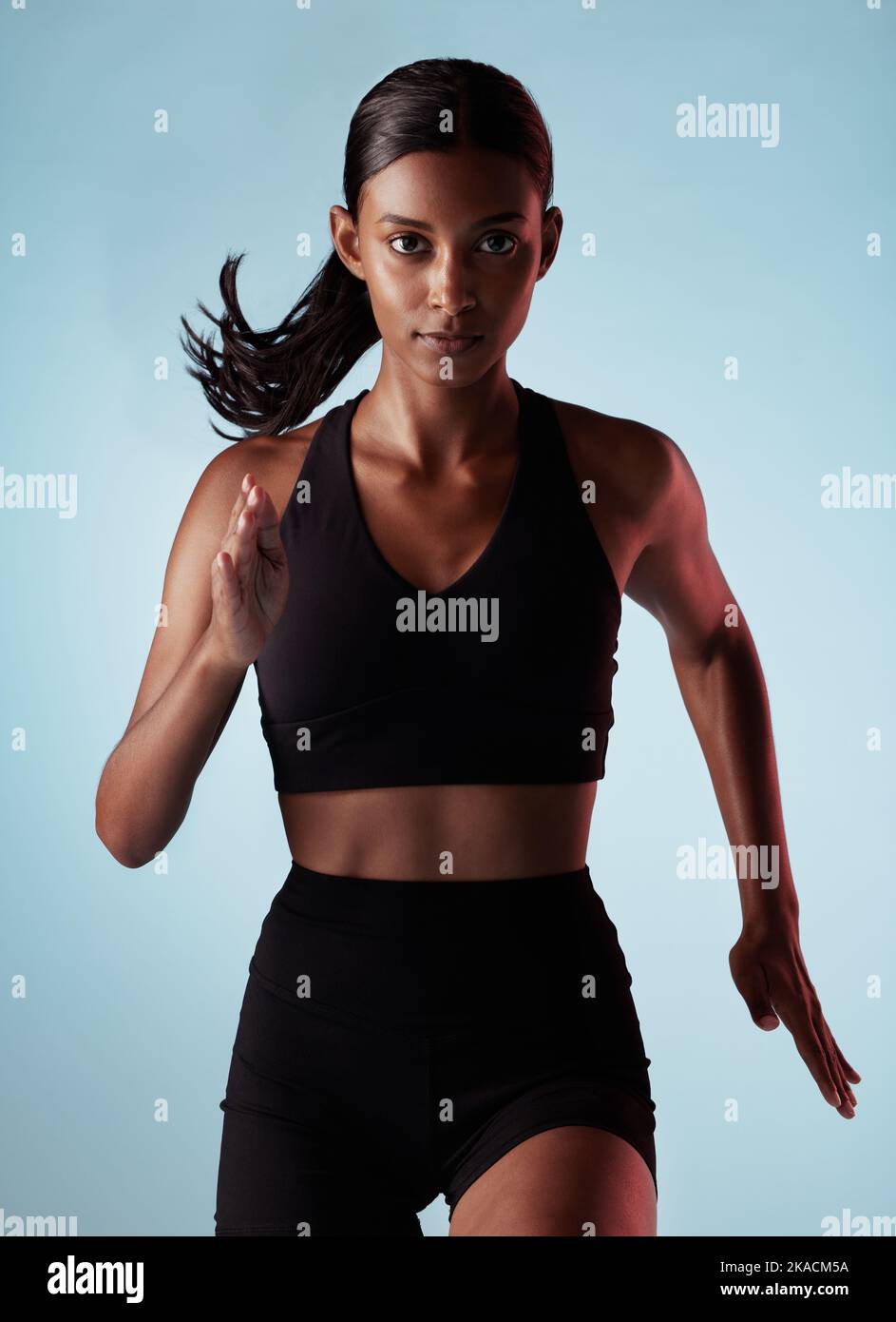 Fitness, running and energy with portrait of woman training in studio for health, power and endurance. Stamina, sprinting and cardio with runner for Stock Photo