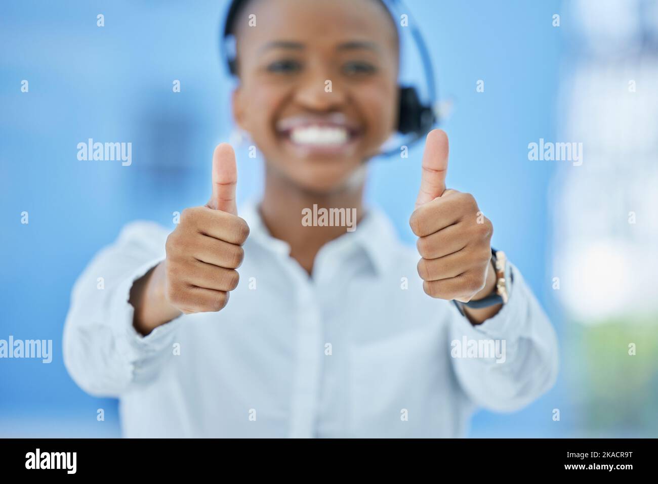 Thumbs up, success and black woman consultant at call center with customer service promotion, achievement or win. Happy, yes and agreement of Stock Photo