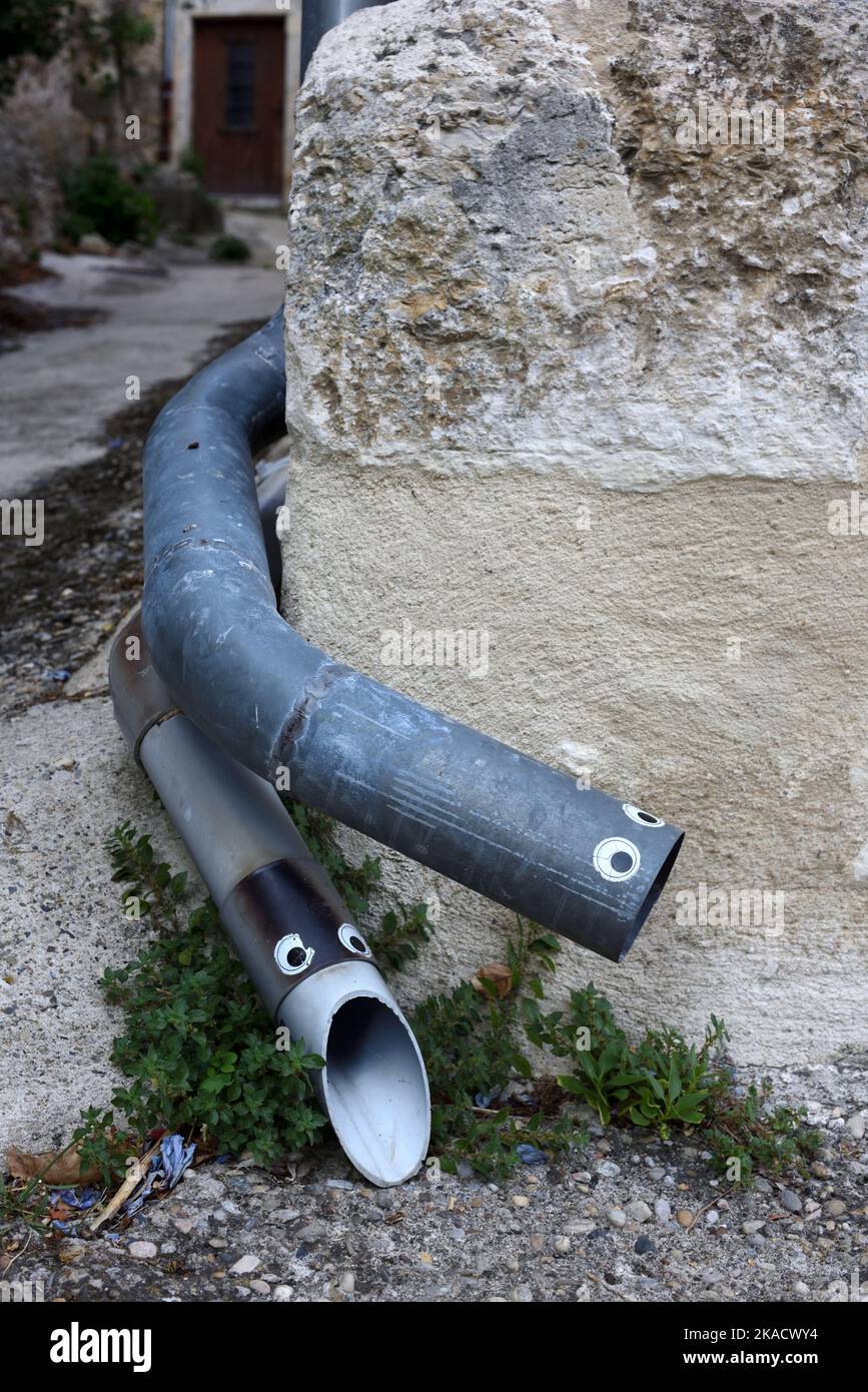 Funny or Amusing Snake-like Gutters or Downpipes Decorated with Stick On Eyes Stock Photo