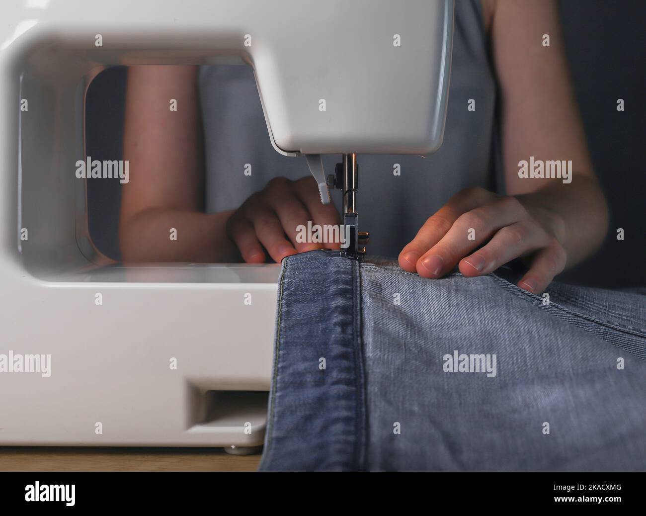 Working with denim textile on sewing machine. Fashion design Stock