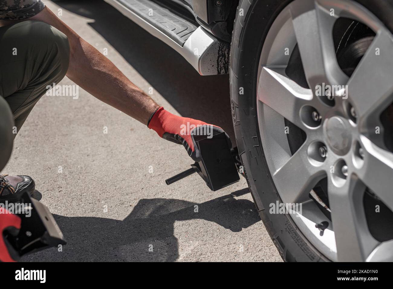 Image showcasing Wheel chocks in male hands near car tire Stock Photo - Alamy