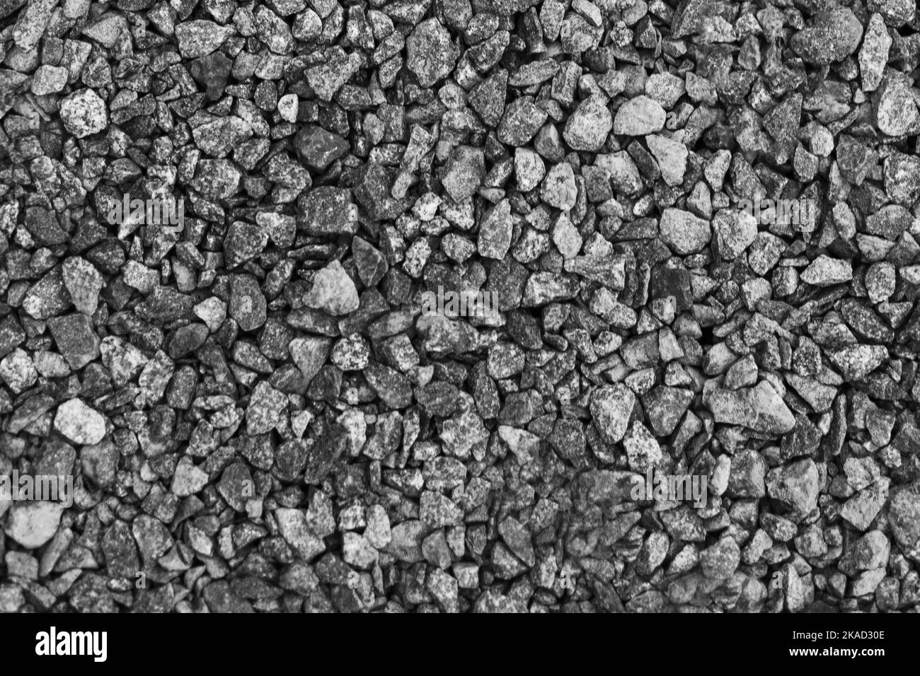 Gray small rocks ground texture. black small road stone background. gravel pebbles stone seamless texture. dark background of crushed granite gravel Stock Photo