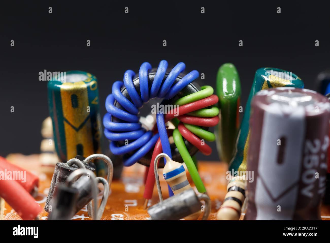 A coil on a ferrite ring wound with colored wires. Macrophotography