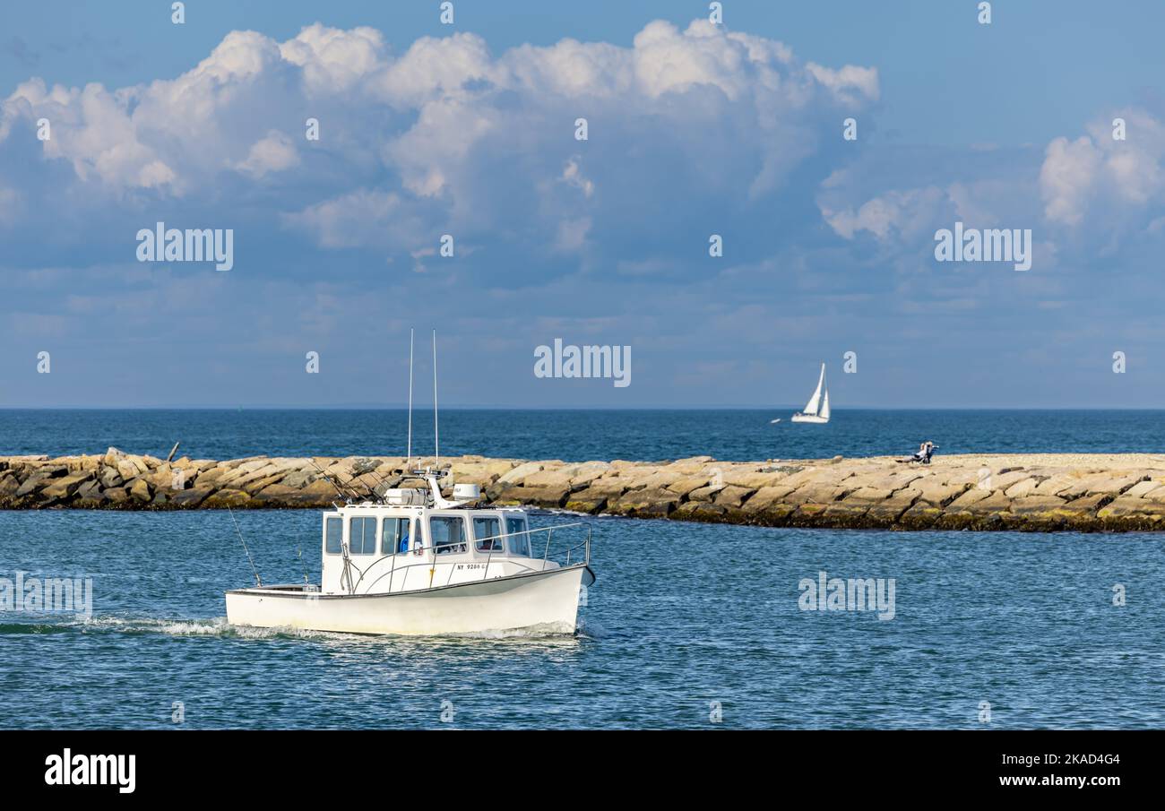 Small white fishing boat returning to Montauk, NY Stock Photo