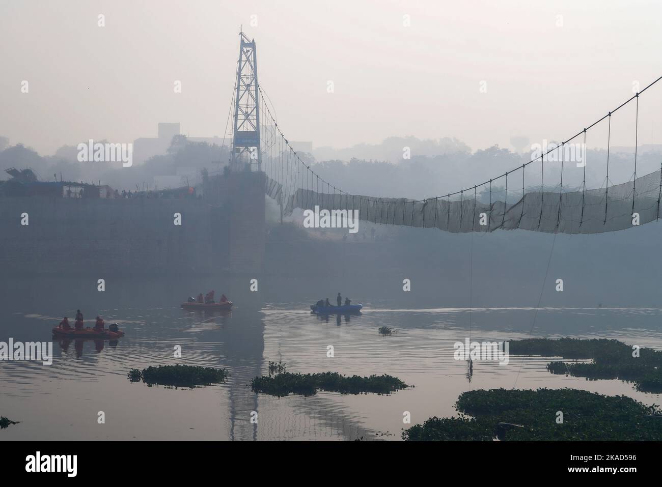 (221102) -- GUJARAT, Nov. 2, 2022 (Xinhua) -- Rescuers on boats search in the Machchhu River near a collapsed bridge in Morbi district of India's western state of Gujarat, Nov. 2, 2022. India's western state of Gujarat Wednesday observed state-wide mourning to condole the death of more than 100 people who were killed following the collapse of a century-old British-era pedestrian suspension bridge, officials said. (Str/Xinhua) Stock Photo