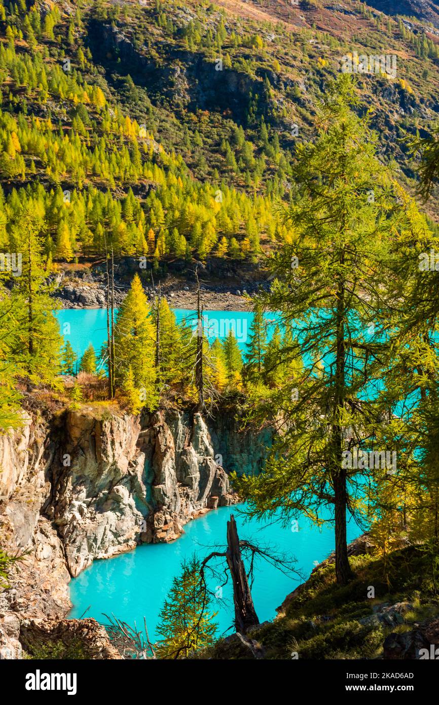 Autumnal landscape of the Lake Place Moulin, an artificial glacial lake with turquoise water in the italian Alps, on the border with Switzerland Stock Photo