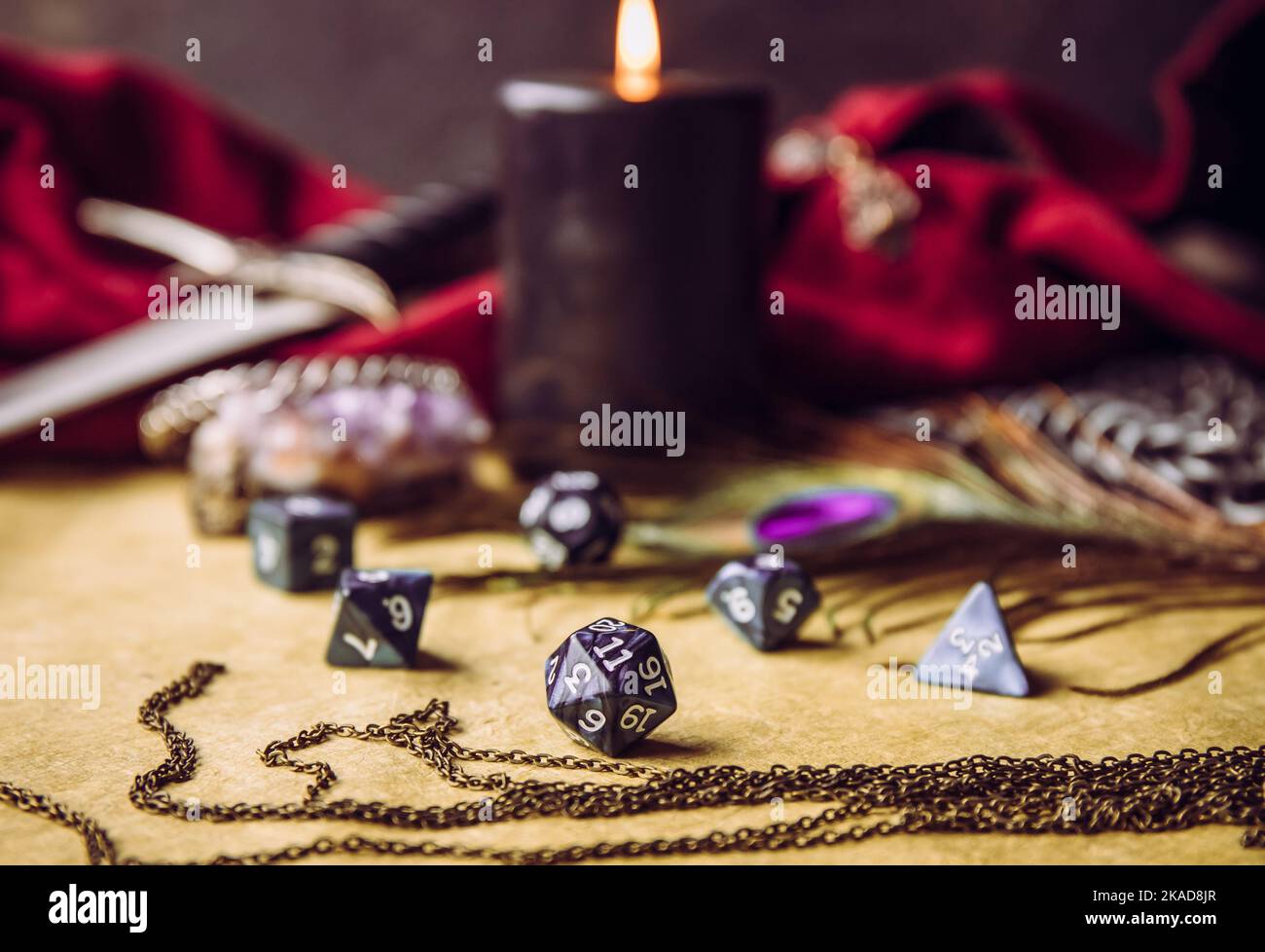 Fantasy role play board game still life concept. Selective focus on dice. Background decorated with various character objects tools. Stock Photo