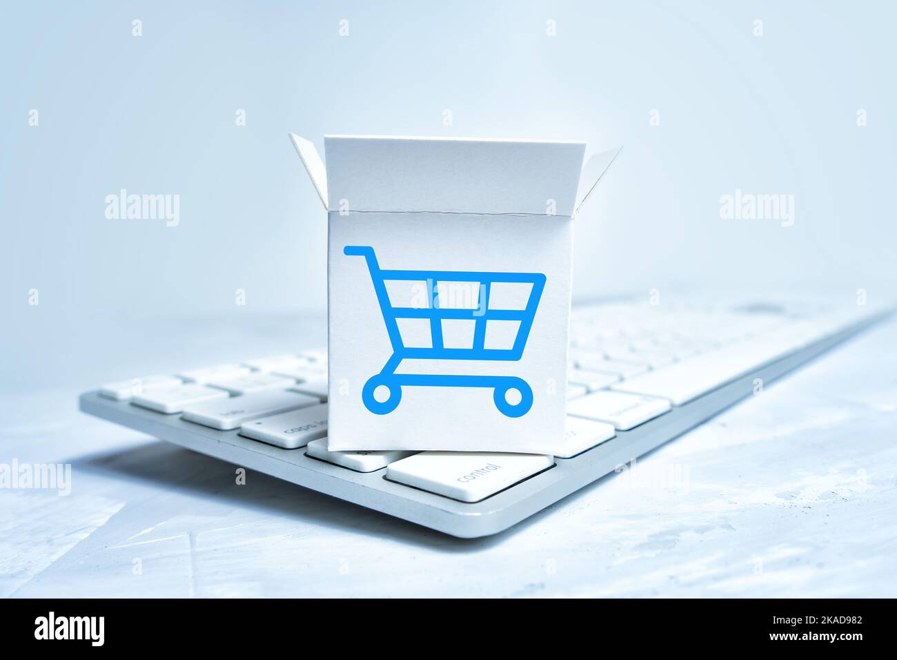Unpacked tiny shipping box with a shopping cart marking placed on a new keyboard. Stock Photo