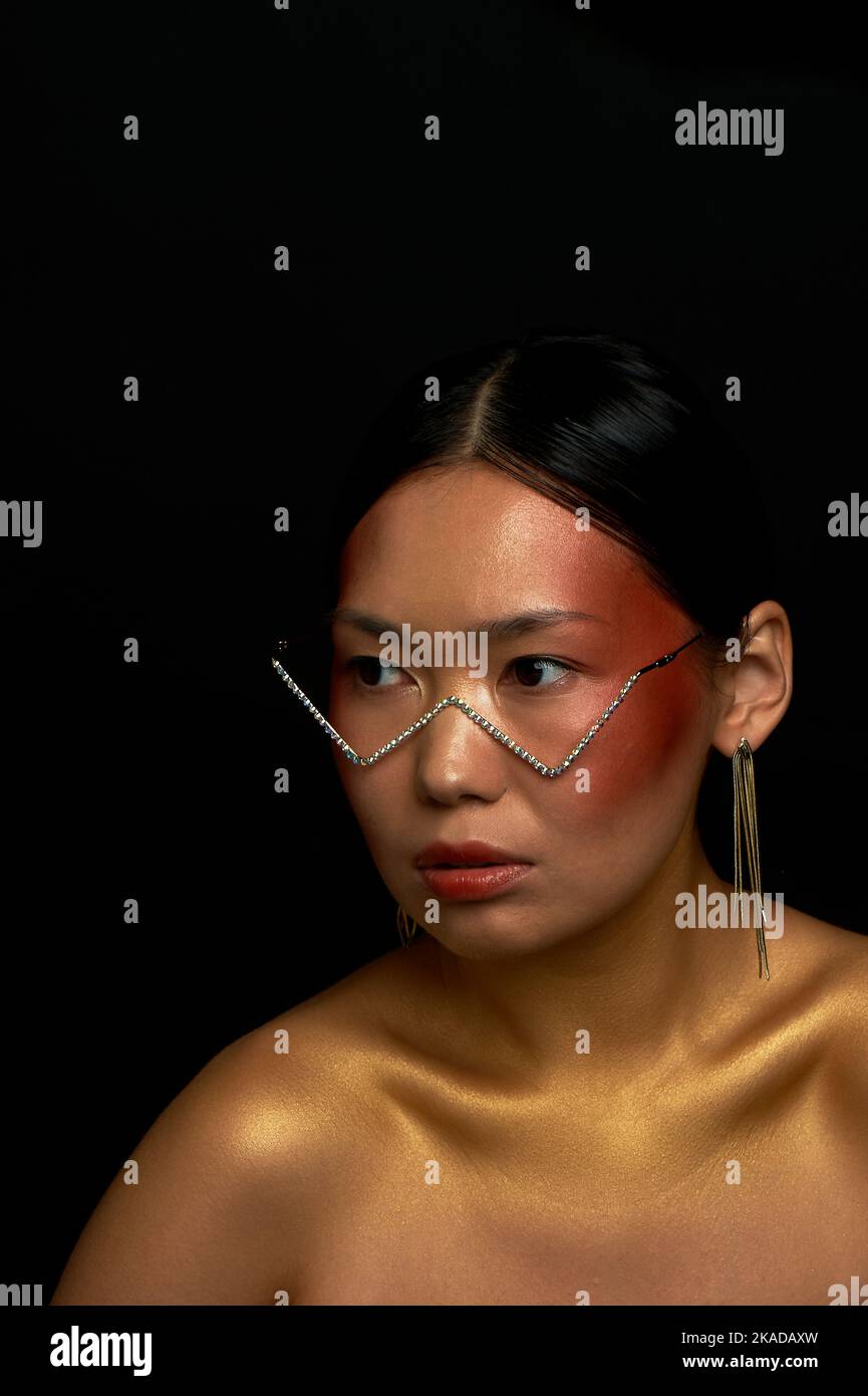 Beautiful Asian type girl in glasses with rhinestones. Optics, beauty salons. Stock Photo