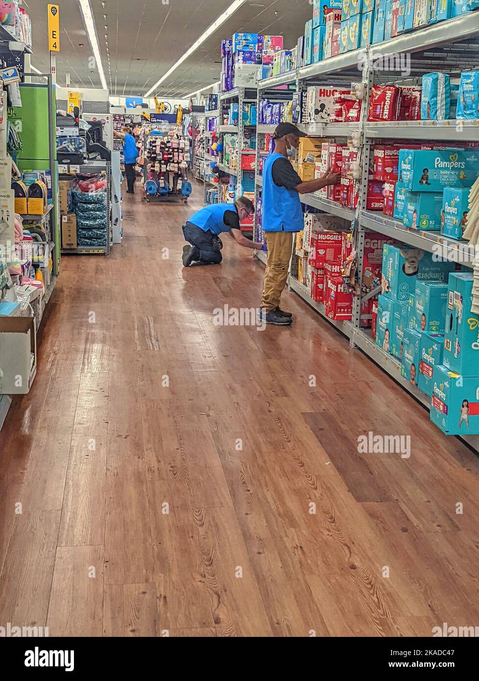 A vertical shot of two men stocking shelves at Walmart Stock Photo Alamy