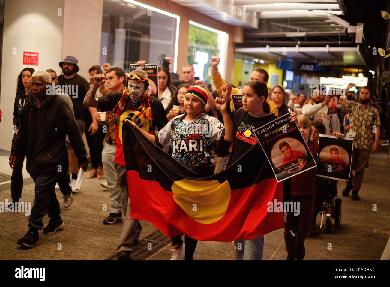 Protesters carry candles and flags during a vigil in Brisbane on 2