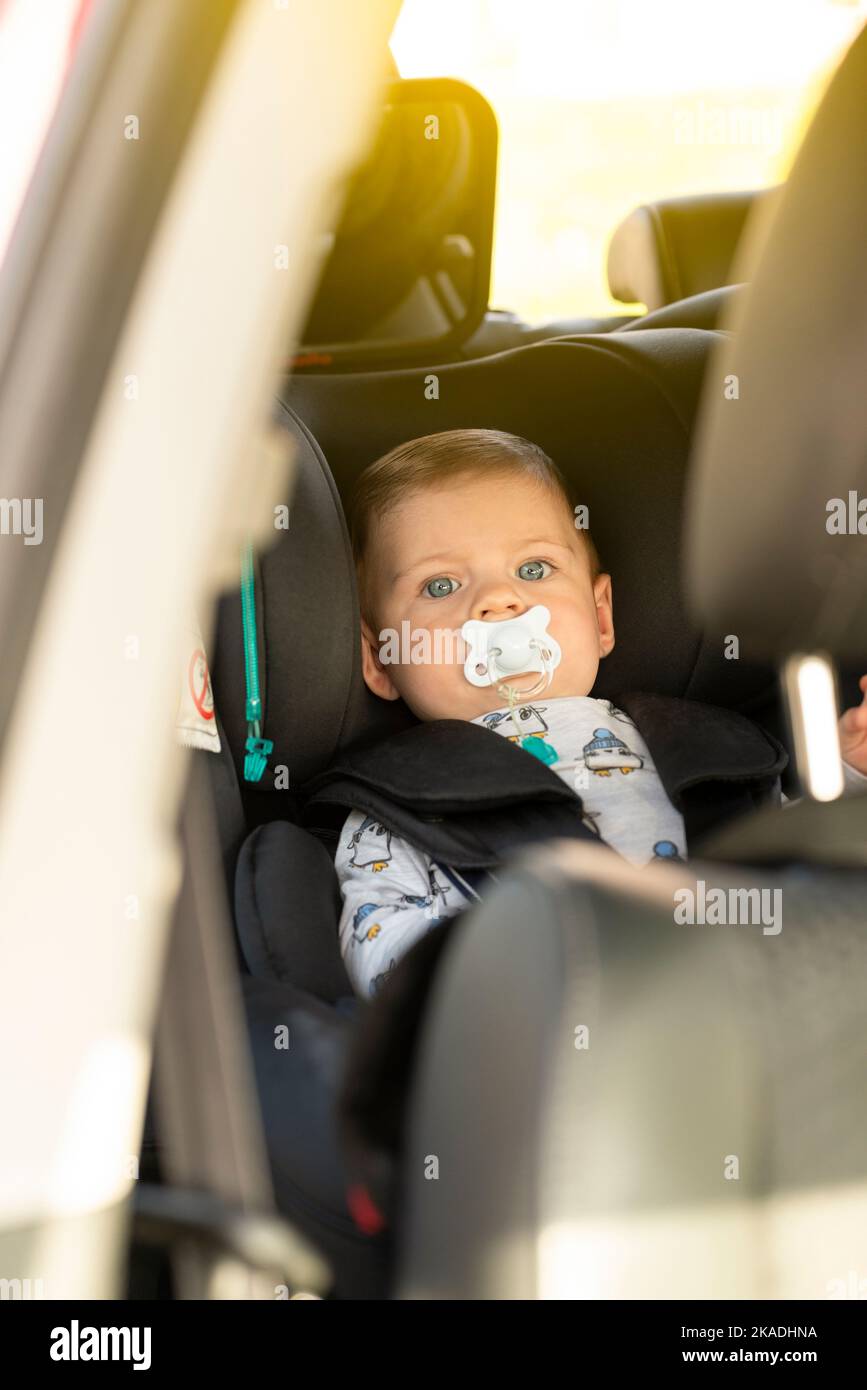 Baby in the car seat with a pacifier Stock Photo Alamy