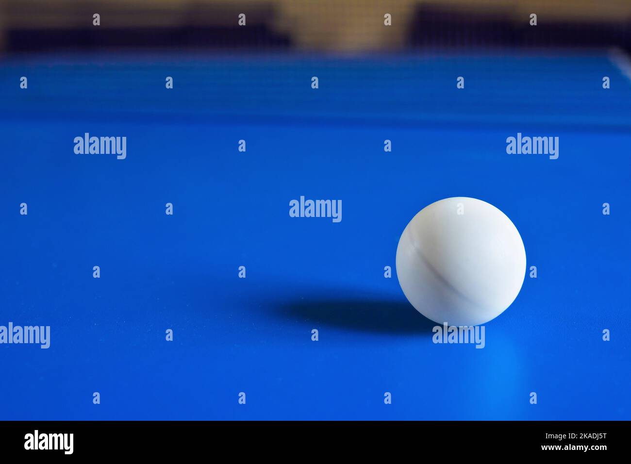 White table tennis ball on blue table. Ball for playing ping pong