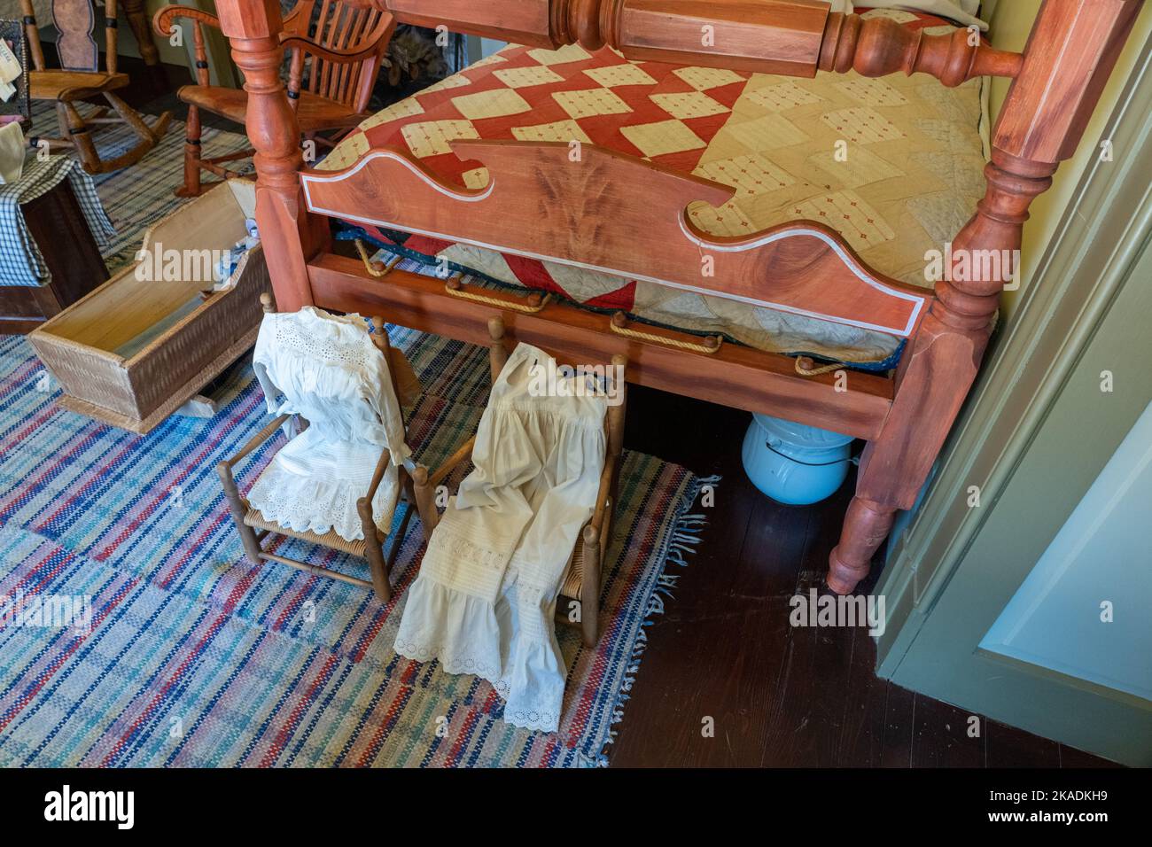 Antique furnishings including children's clothing a lodging room of the Cove Creek Ranch Fort, built in 1867, Cove Fort, Utah.  Note the chamber pot u Stock Photo