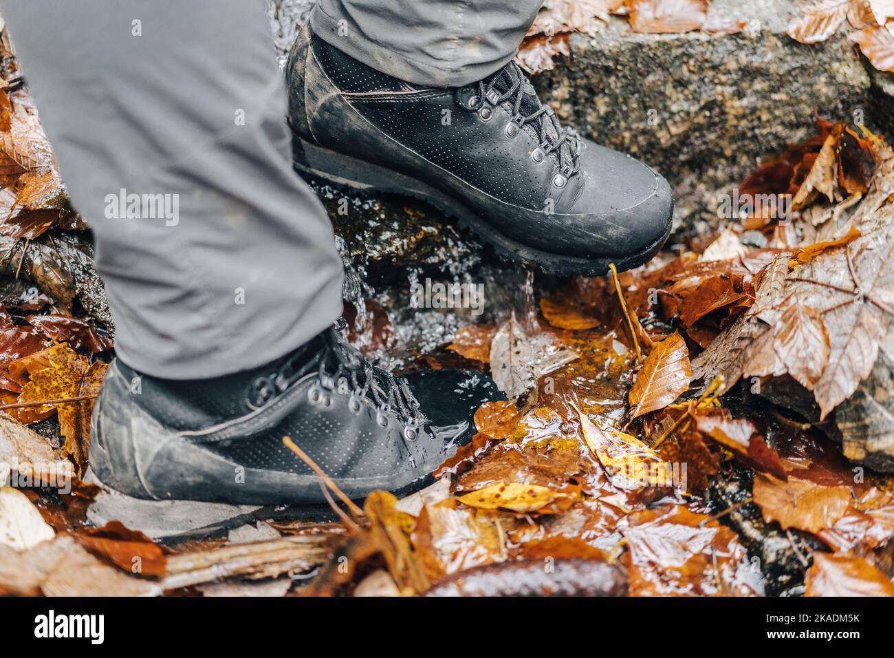Close up detail photo of hiking or trekking boots in muddy autumn