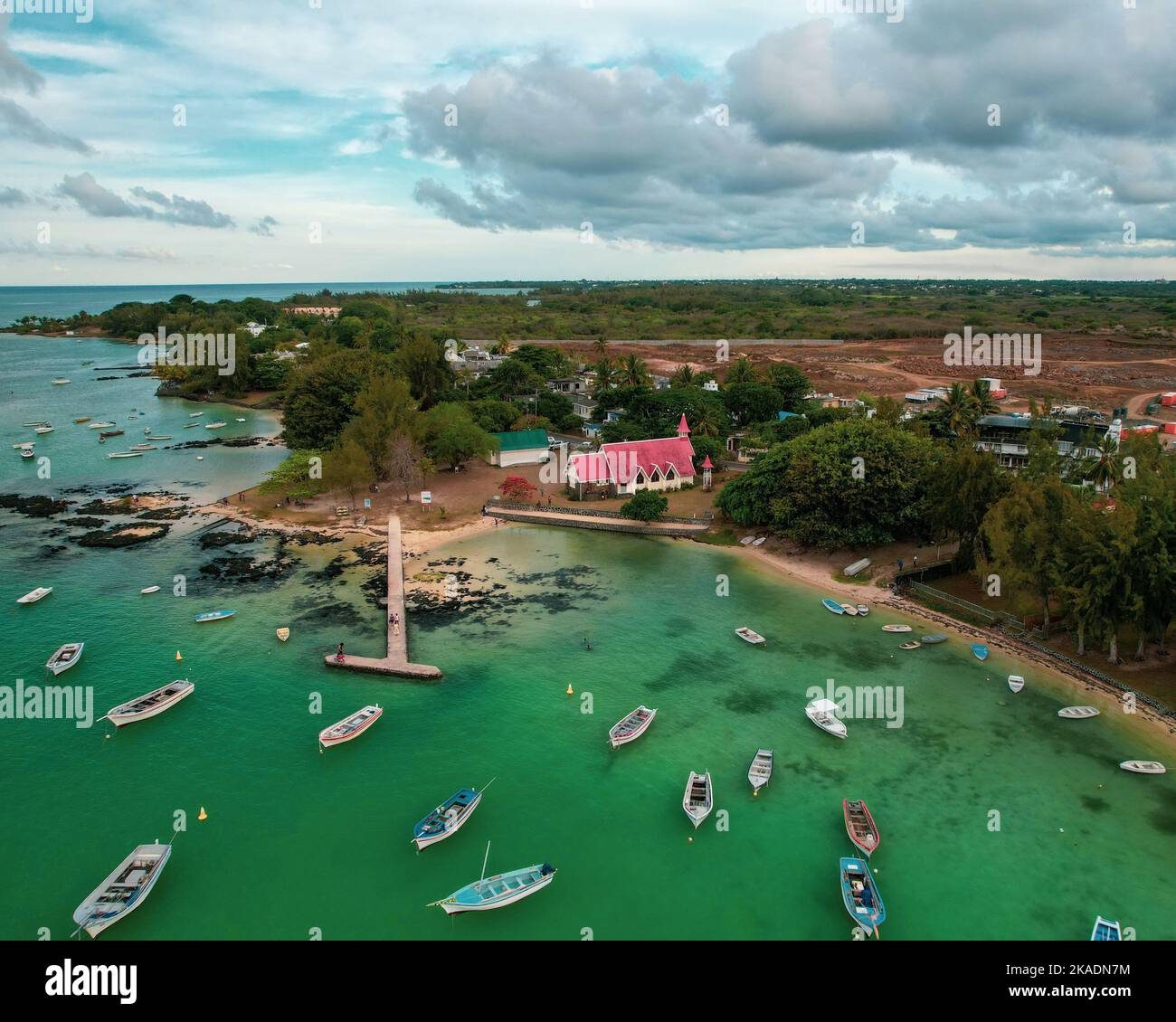 An aerial view of a coastal town with boats sailing near the beach ...