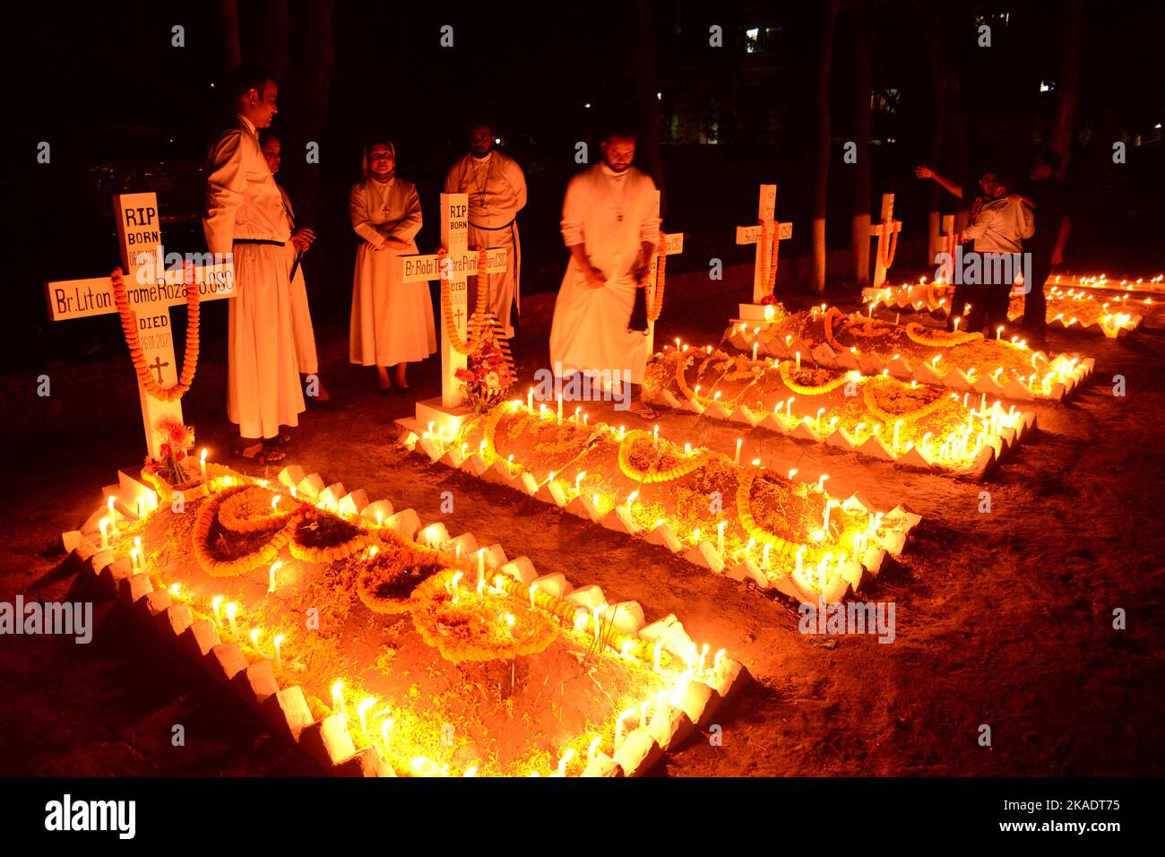 Dhaka, Bangladesh, on November 2, 2022. Dhaka, Bangladesh, on November 2, 2022. Dhaka, Bangladesh, on November 2, 2022. Christian devotees light candles on graves of relatives during the celebrations of All Souls Day in a cemetery at Wari Cemetery of Holy Cross Church in Dhaka, Bangladesh, on November 2, 2022. Stock Photo