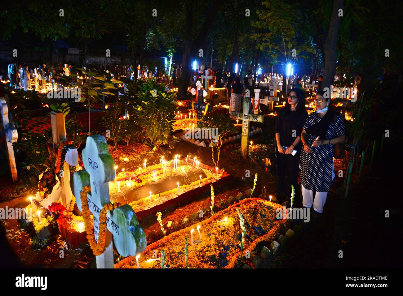 Dhaka, Bangladesh, on November 2, 2022. Dhaka, Bangladesh, on November 2, 2022. Christian devotees light candles on graves of relatives during the celebrations of All Souls Day in a cemetery at Wari Cemetery of Holy Cross Church in Dhaka, Bangladesh, on November 2, 2022. Stock Photo