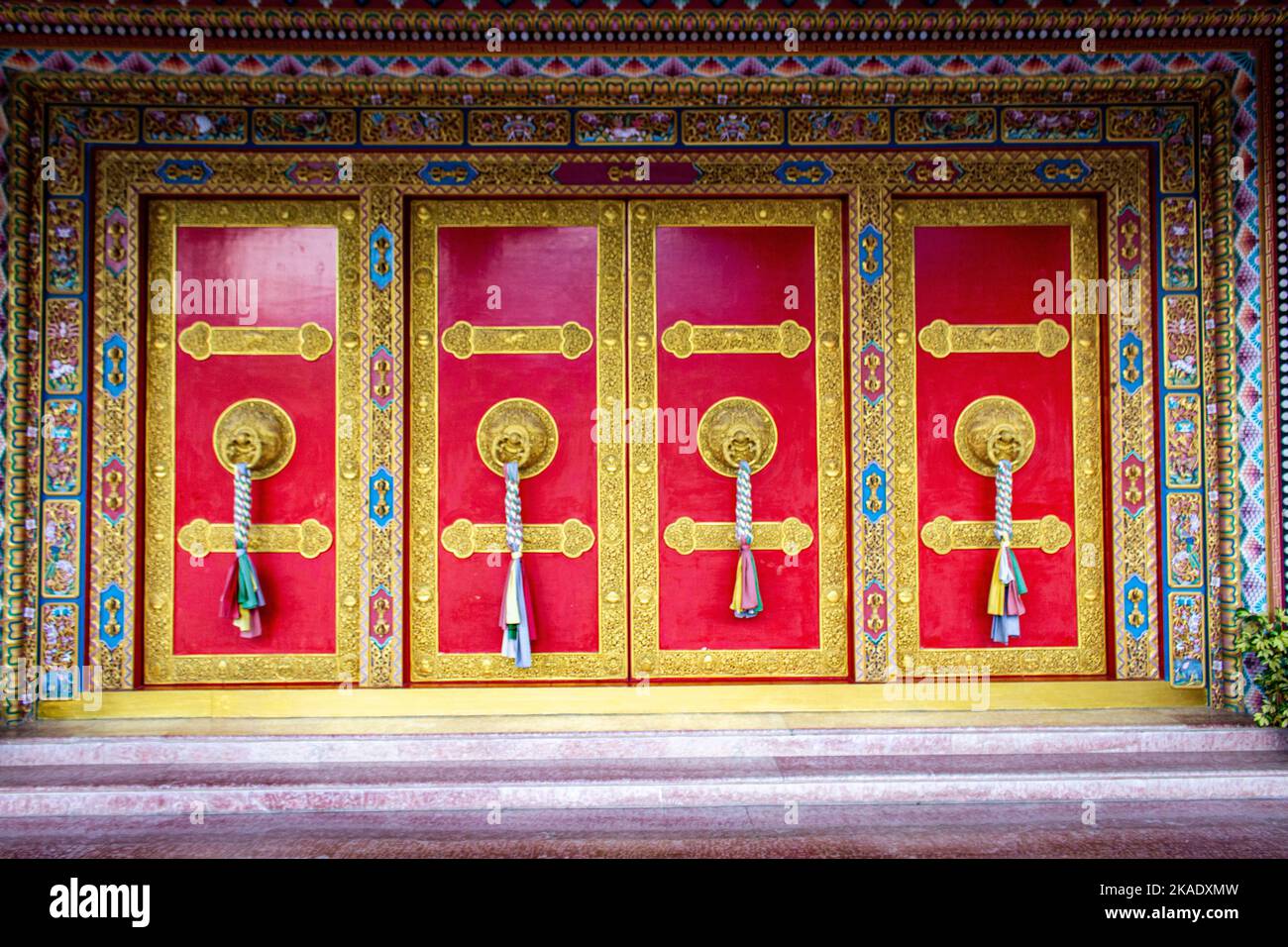 The beautiful entrance of a Buddhist temple with golden doorknobs Stock