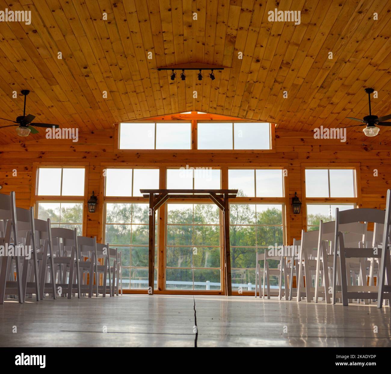 An interior of the wedding venue with white chairs and a wooden altar