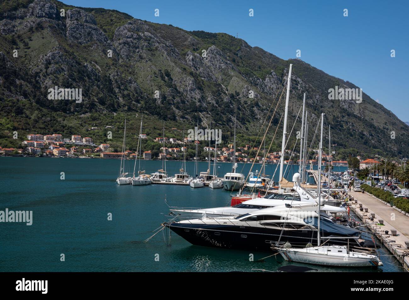 Kotor, Montenegro - April 29, 2022: Sailings yachts, motorboats and small fishing boats moored at the pier in the Kotor bay. Mountains in background. Stock Photo