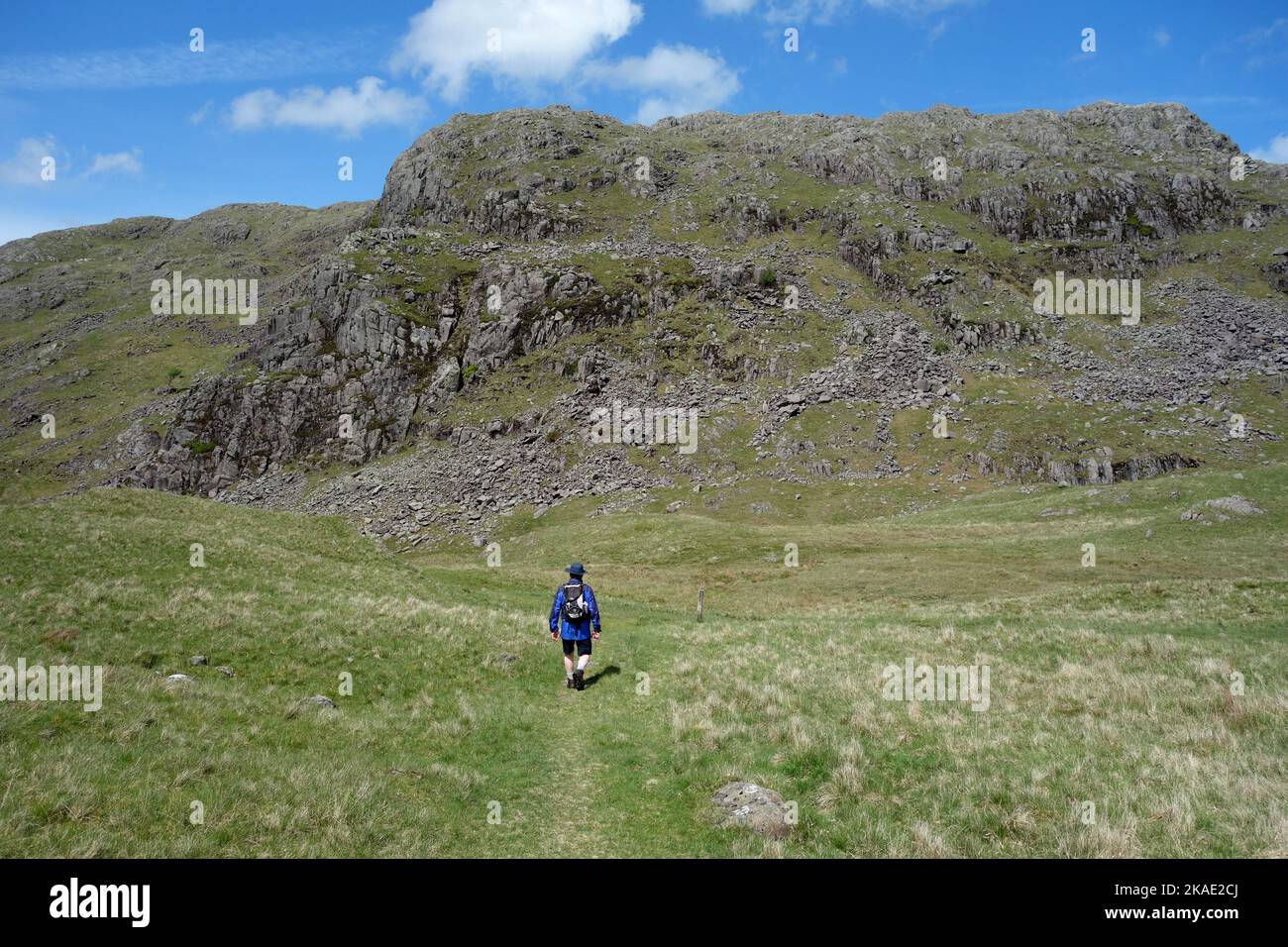 Man Walking on Path to 'Border End' at the Top of the Hardknott Pass from the Wainwright 'Harter Fell' in Eskdale, Lake District National Park. UK. Stock Photo