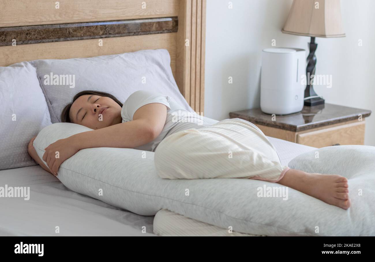 Close up view of a pregnant woman sleeping on the bed with the